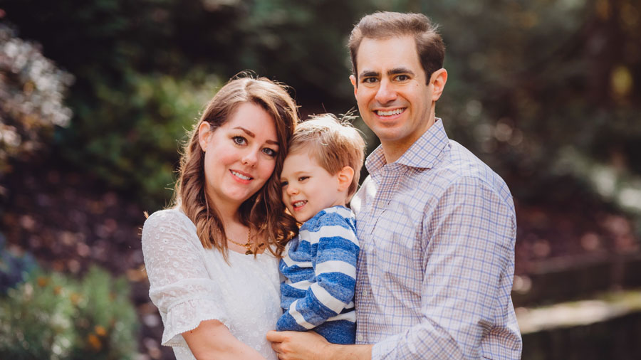 Karla Kaplan and her husband hold their young son as they pose for a family portrait.