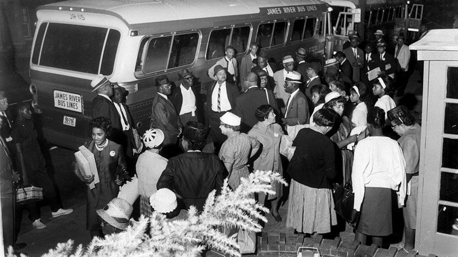 Black people in the 1960s prepare to board a bus