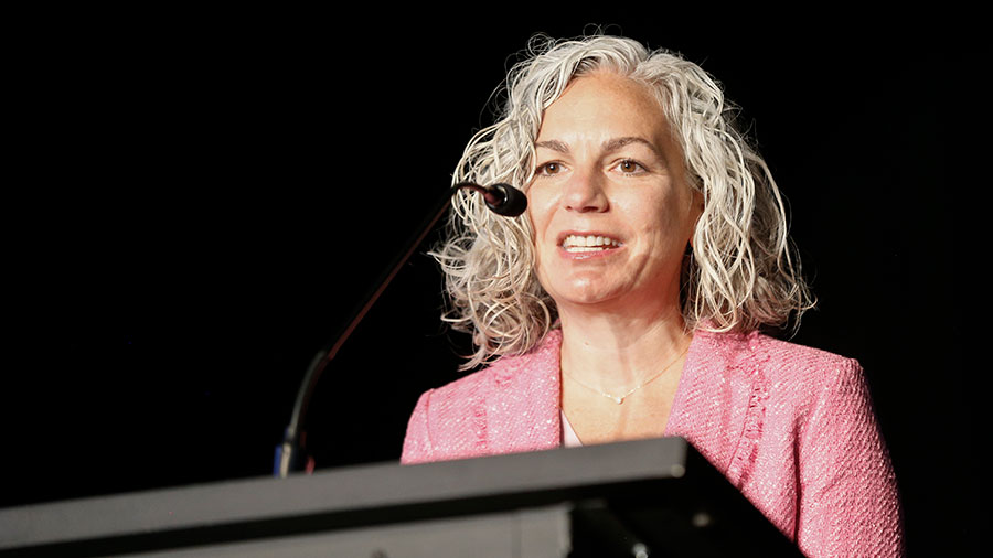 Standing behind a podium, Laura Clark of United Way of Central Carolinas speaks into a microphone.