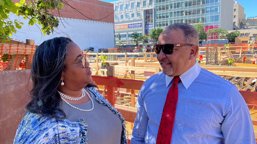 Gigi Dixon and Marc Morial stand looking at each other. In the background is a construction site.