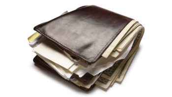 A wallet overstuffed with money and receipts.