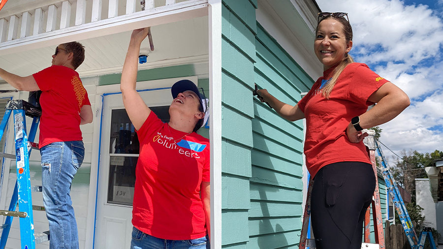 Three people in red Wells Fargo Volunteer T-shirts are in various stages of painting a house.