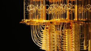 A gold-colored quantum computer hangs in a dark room.