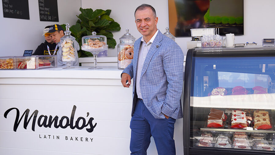 A person poses in front of a bakery