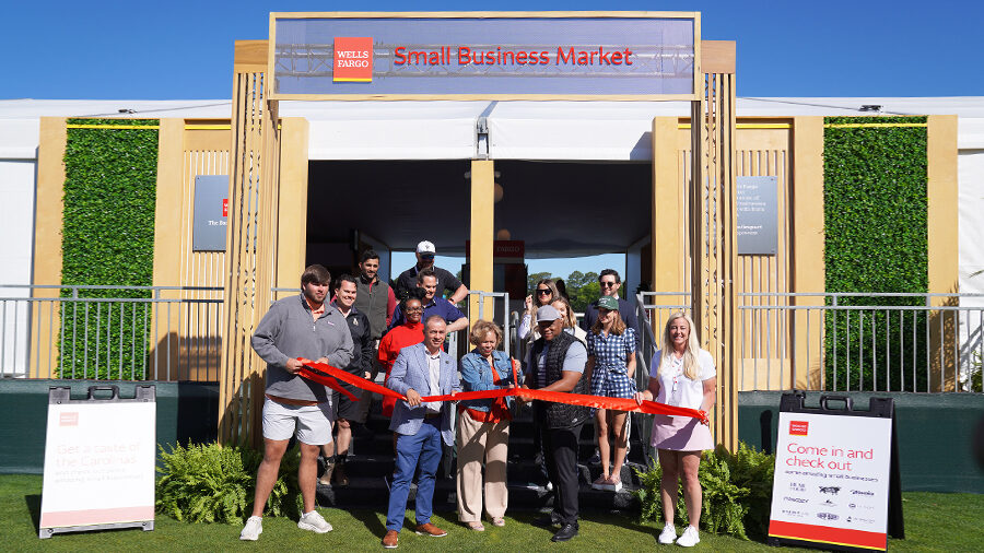 A group of people cut a ribbon in front of the Wells Fargo Small Business Market.