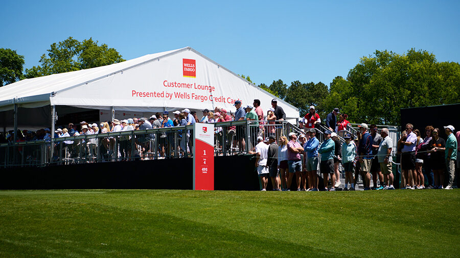 Spectators gather outside the Customer Lounge presented by Wells Fargo Credit Cards tent.