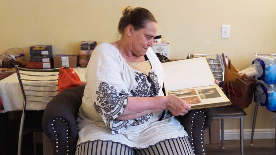 Karrie, a resident of Orchid, flips through pages of a book of her photos.