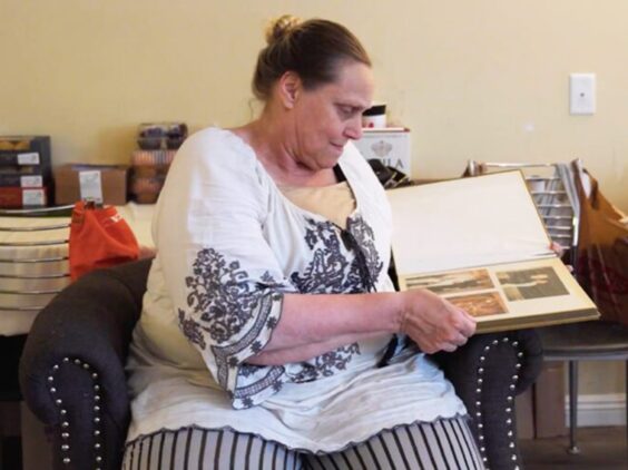 Karrie, a resident of Orchid, flips through pages of a book of her photos.