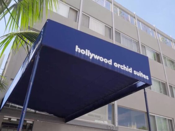 The Orchid, a Project Homekey housing project, still shows signs of its former life as the Hollywood Orchid Suites hotel, such as an awning with the former name.
