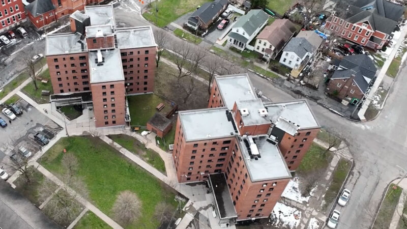 An aerial view of two X-shaped seven-story apartment buildings