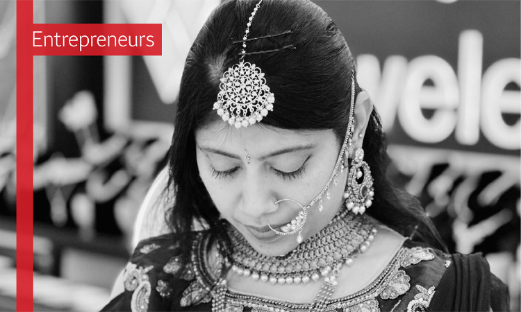 The text Entrepreneurs over a black and white image of a woman in elaborate jewelry