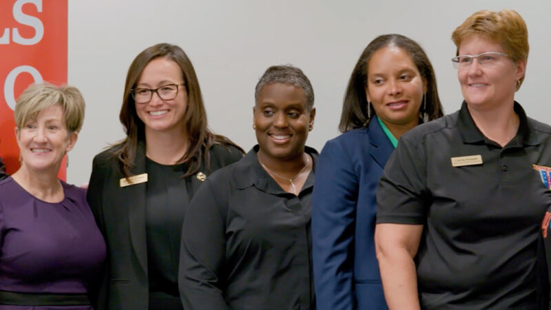 Five women veterans are standing together smiling.