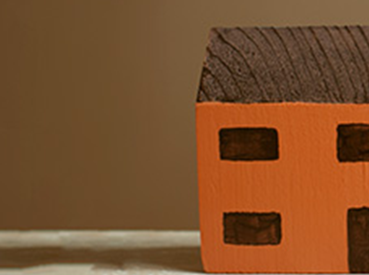 A simple toy wooden house in the corner of the frame.