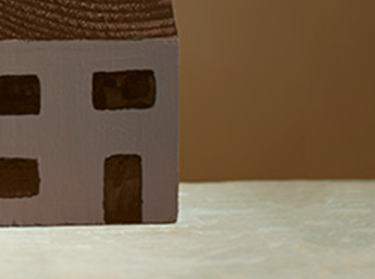 A simple toy wooden house in the corner of the frame.