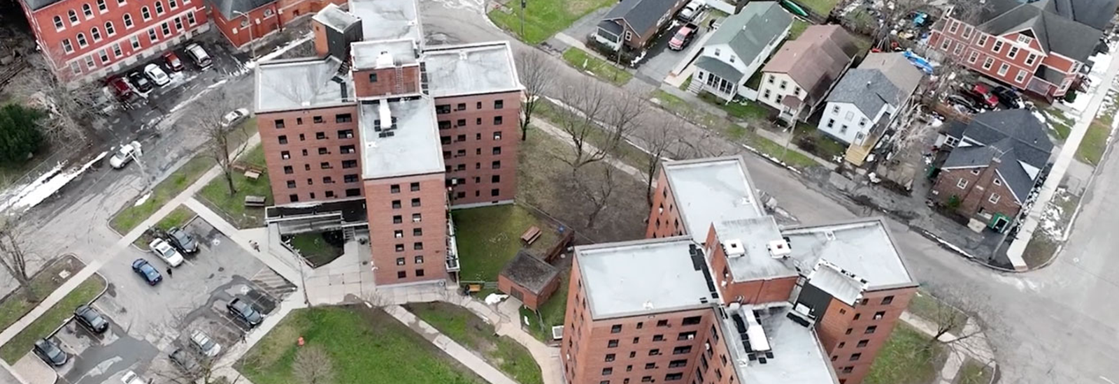 An aerial view of two X-shaped seven-story apartment buildings