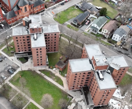 An aerial view of two X-shaped seven-story apartment buildings