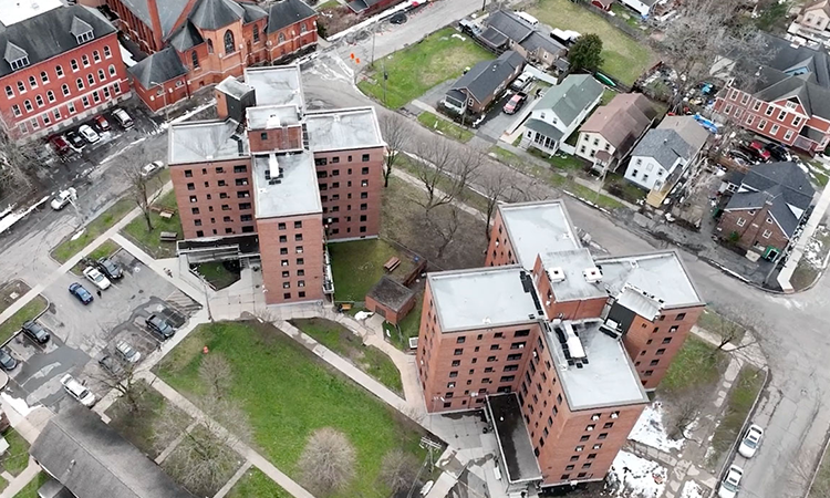 An aerial view of two X-shaped seven-story apartment buildings