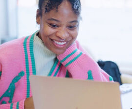 A woman and a man look at a laptop screen