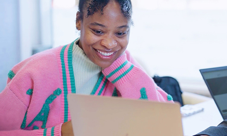 A woman and a man look at a laptop screen