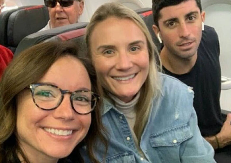 People on a plane smile at the camera