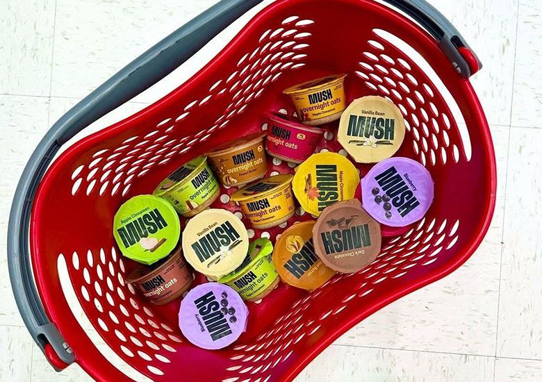 Small tubs of MUSH overnight oats are grouped together in a shopping basket.