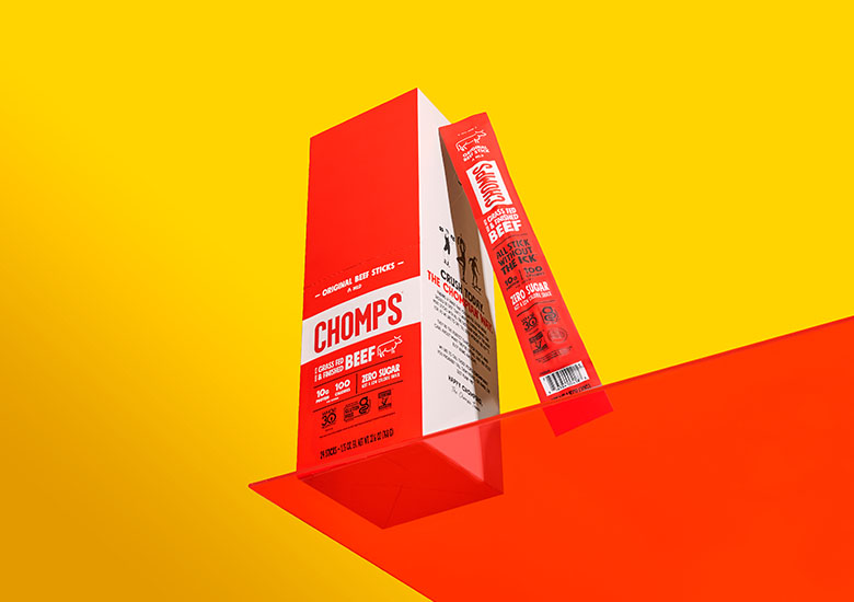 A box of Chomps meat stick products sit on a brightly colored shelf.