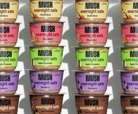Small tubs of MUSH overnight oats stacked in colorful rows on a shelf.
