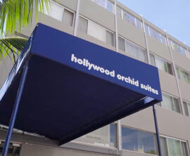 A building is shown with a blue canopy that reads hollywood orchid suites