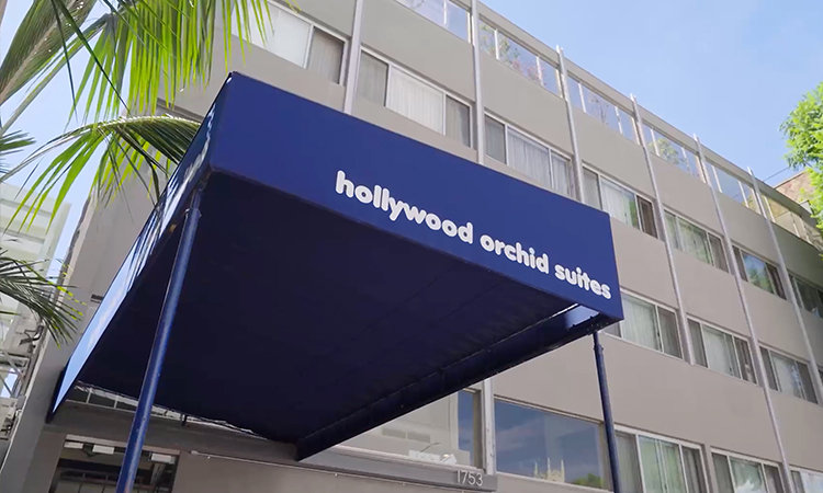 A building is shown with a blue canopy that reads hollywood orchid suites