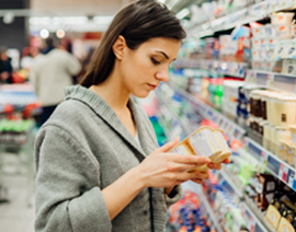 A woman examines a food label in a grocery store