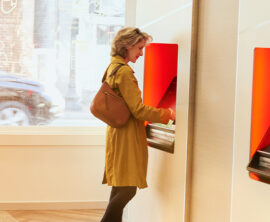 A woman stands at an ATM