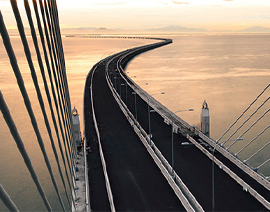 an arial view of a winding road traveling over water.