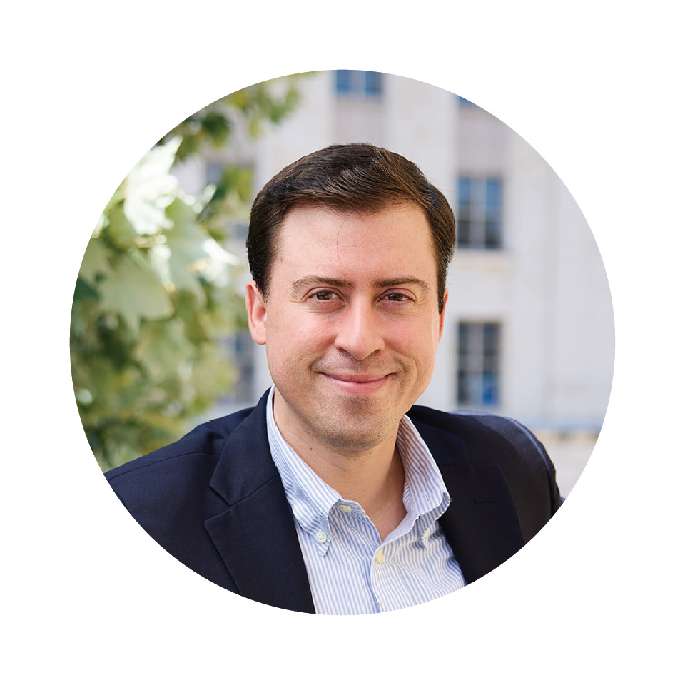 A headshot of a man in a blue sport coat and button-don shirt.