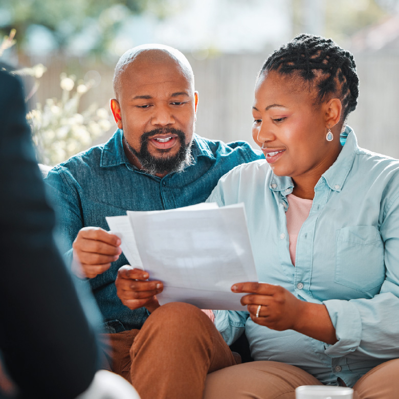 Two adults review a document during a meeting.