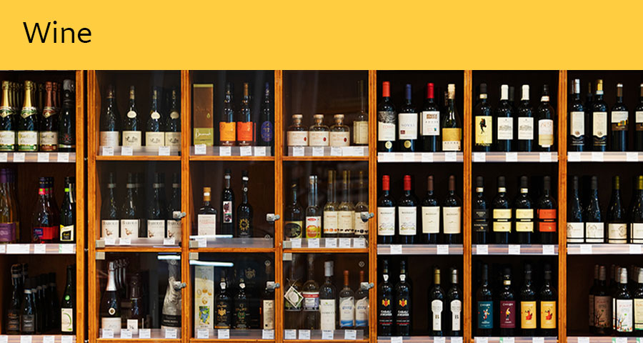 Under the heading “Wine,” there is a fully stocked display case containing various types of wines.