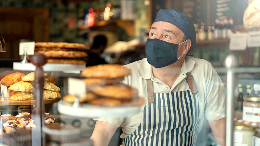 A baker wears a face covering while working.