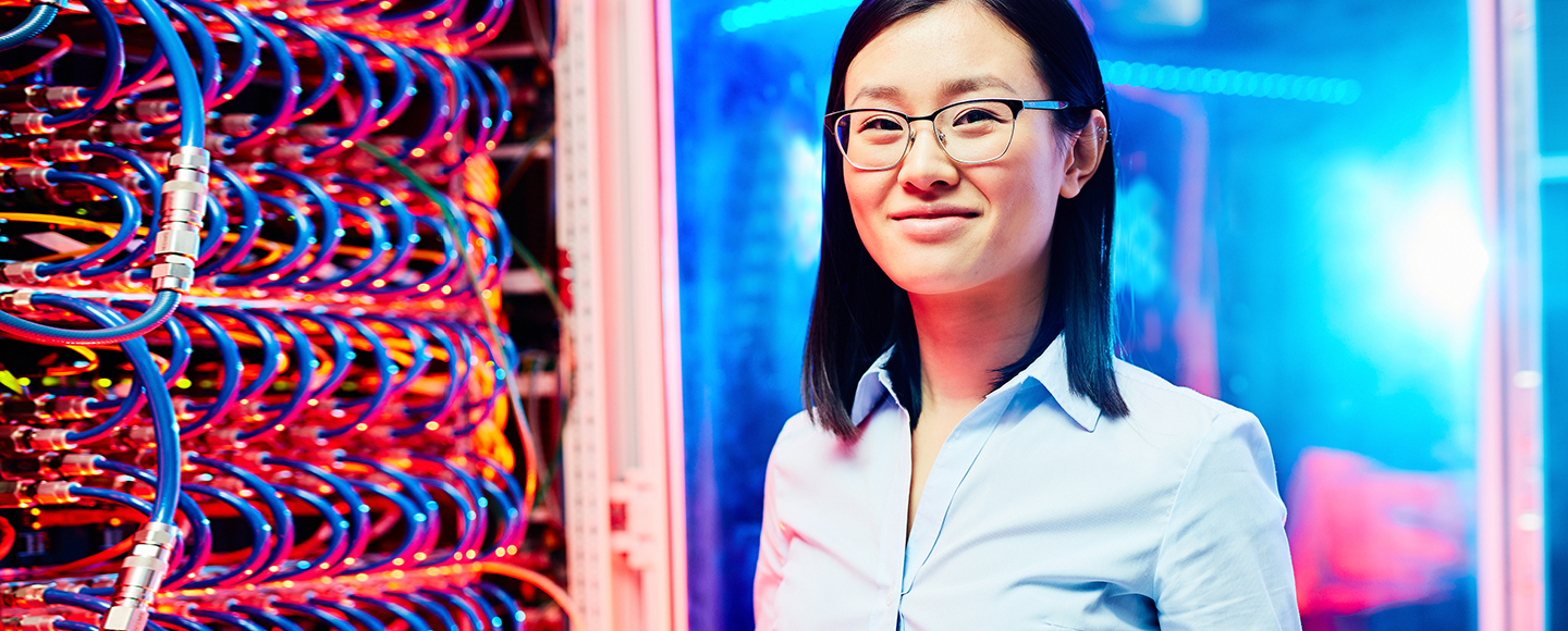 Image of young woman in glasses next to blue wires