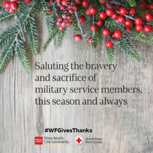 'Saluting the bravery and sacrifice of military service members, this season and always' e-card text on a photo of berries and greenery. #WFGivesThanks, 'Many hearts. One community.', and Red Cross logos are centered at the bottom.