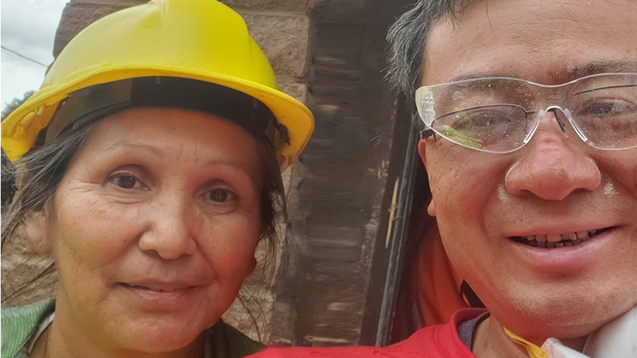 A woman and man in hard hat and protective glasses stand next to each other.