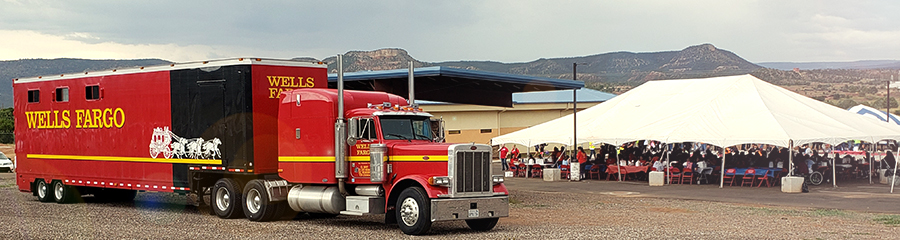 A Wells Fargo truck parked near a large outdoor event tent.