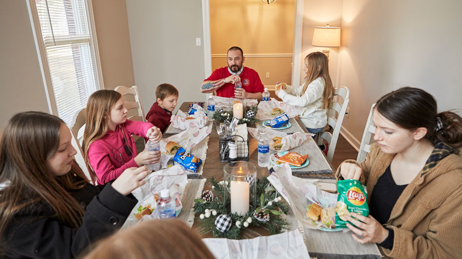 The Myatt family eat a meal at their dining room table.
